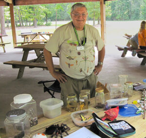 volunteer posed at a picnic table filled with jars and containers