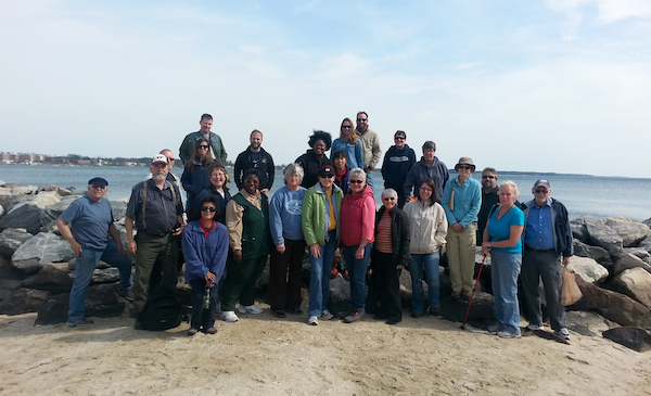 group of more than 20 people posed for a photo on a shoreline