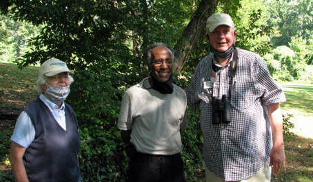 photo of a woman and two men under a tree