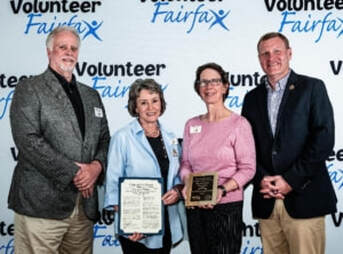 four people posed holding an award plaque