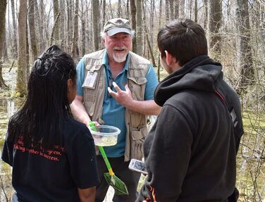 volunteer showing salamander eggs to students
