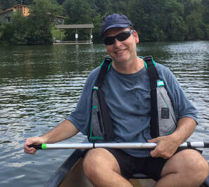 photo of man on the water in canoe