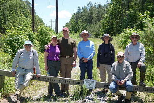 7 volunteers in field clothes at Chilton State Forest road