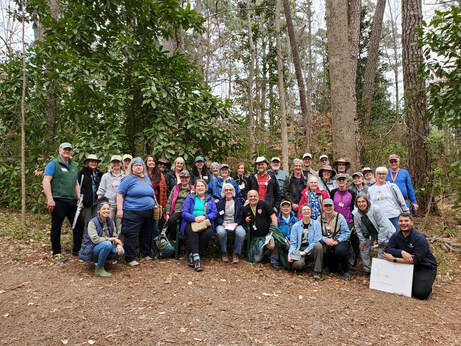 group of more than 30 people posed outdoors in from of trees