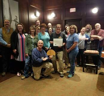 Group of volunteers holding the Volunteer Group of the Year award plaque.