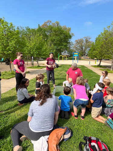 Volunteer shows animals to group of young children and parents