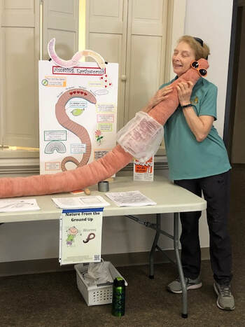 person hugging an earthworm stuffed animal