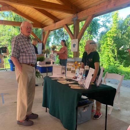 volunteer talking to a visitor at a display booth