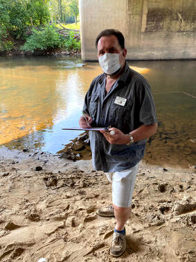 volunteer with clipboard next to river